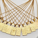 Gold zodiac necklaces with zodiac pendants on a white surface