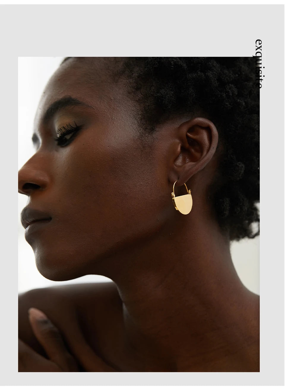 Close-up of a woman wearing gold hoop earrings with a blurred background