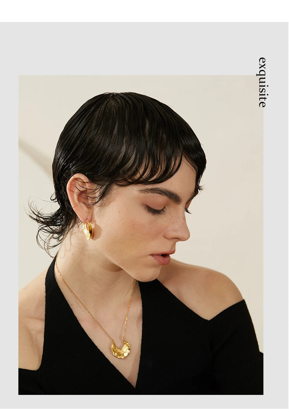 Woman wearing gold earrings and a necklace with a neutral background