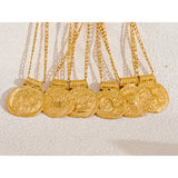 Gold necklaces with coins on a textured white surface
