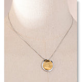 Necklace with a gold pendant on a beige background