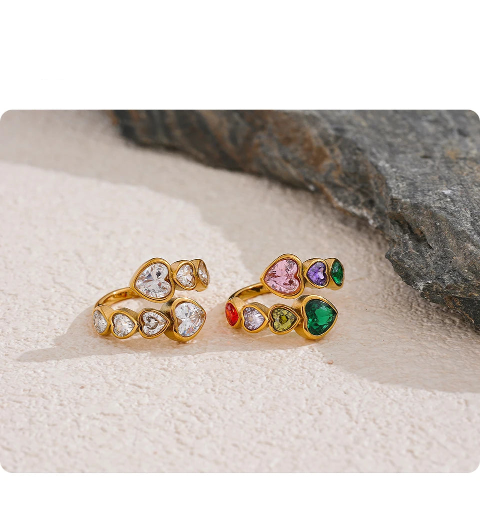 Two gold rings with gemstones on a textured surface