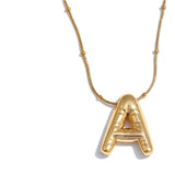Gold necklace with a letter 'A' pendant on a white background
