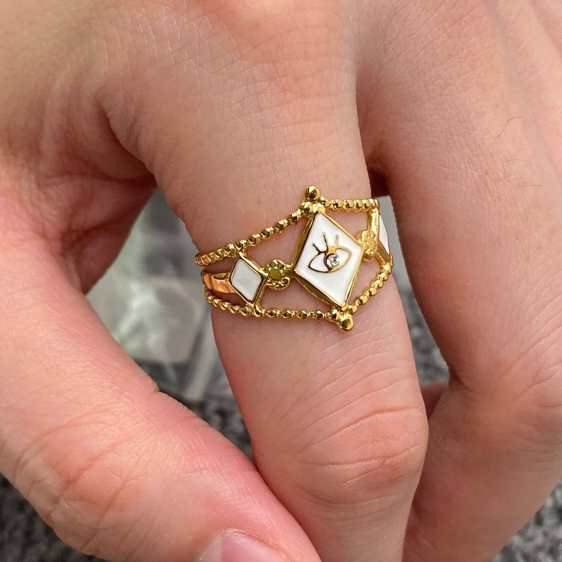 White enamel CZ evil eye ring with gold-plated stainless steel, adjustable fit, perfect for couples or bold accessory lovers.