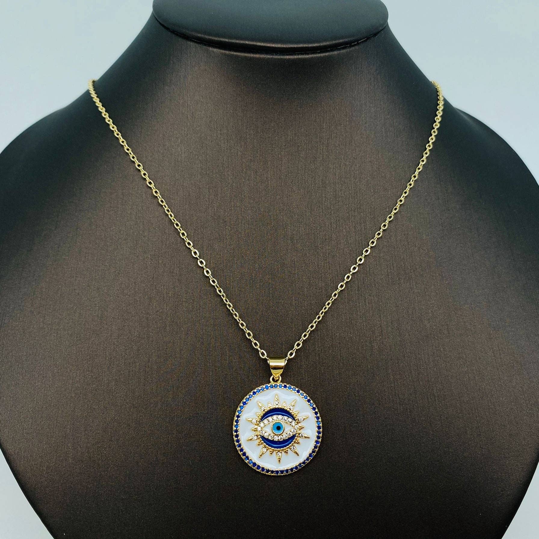 Dainty white enamel evil eye necklace with gold plating and blue stone, offering daily protection and elegant style for women.