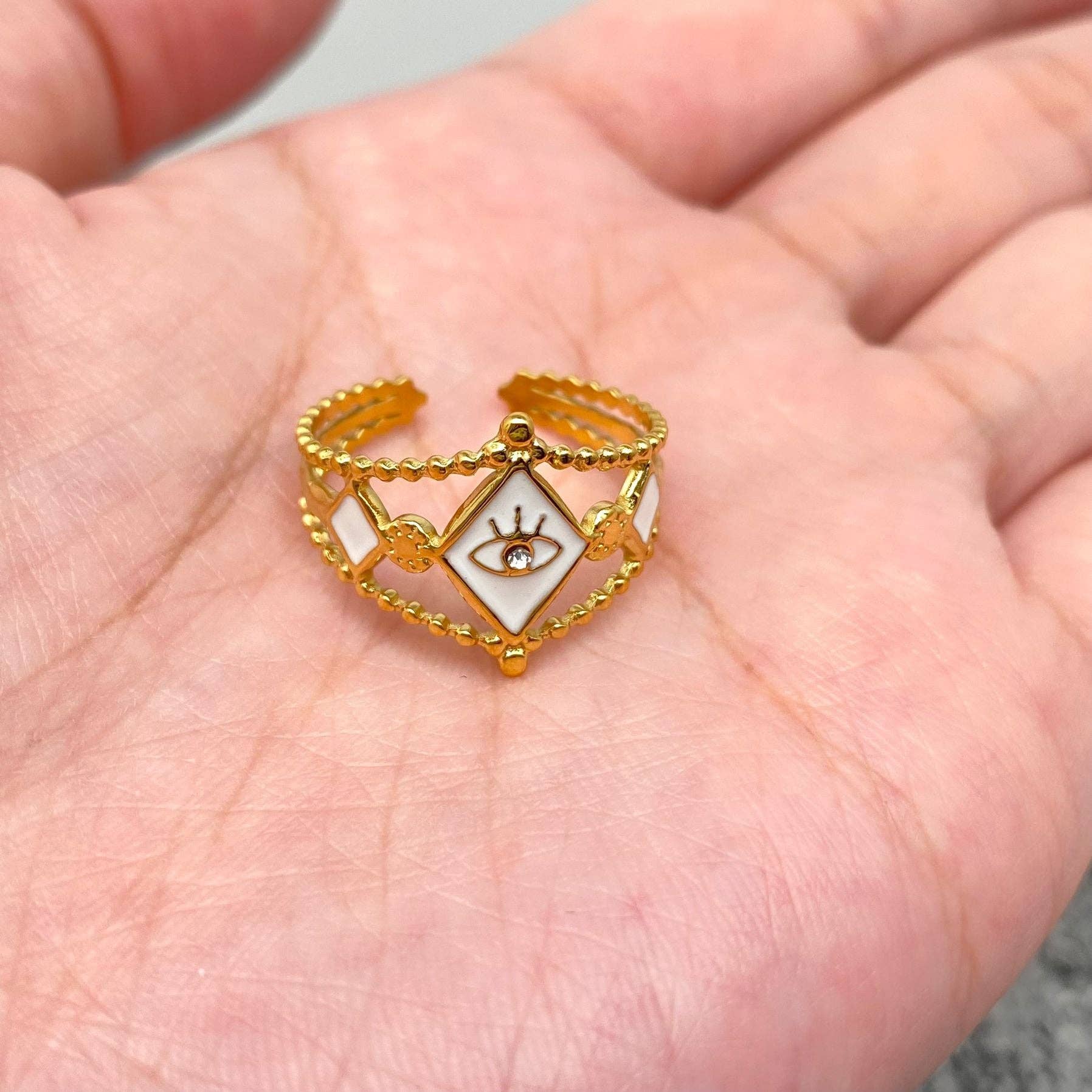 Gold-plated CZ evil eye ring with white enamel and retro charm, made of stainless steel, ideal for everyday or couple wear.
