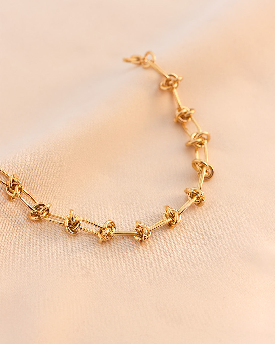 Luxe Gold Woven Knot Necklace, 18K gold-plated, symbolizing strength and connection, perfect for elevating your look with timeless elegance.