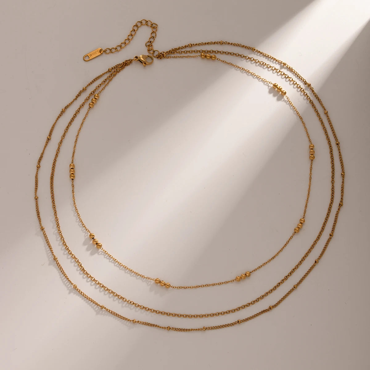 Elegant Layered Gold Necklace with Beads, 18K gold-plated, featuring delicate chains and polished gold beads for a graceful, cascading design.
