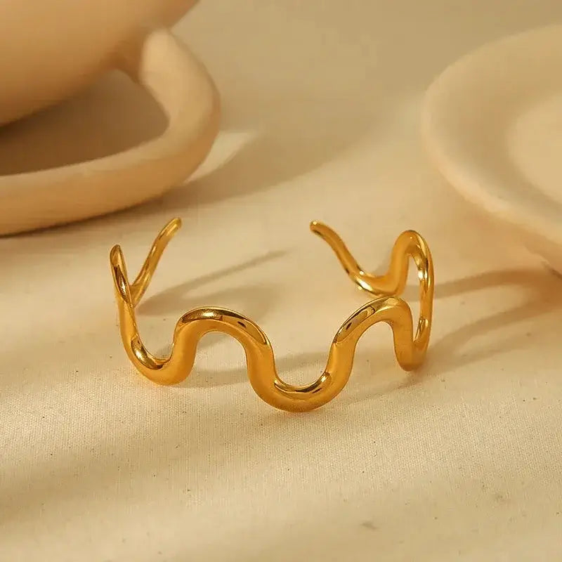 Minimalist wave cuff bracelet made of durable stainless steel with 18K gold plating, featuring smooth bead closure for a comfortable fit