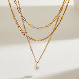 Delicate Triple Chain Necklace with a Natural Pearl Drop, 18K gold-plated, designed to add elegance and shine to any outfit.