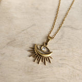 Chic Sunburst Evil Eye Pendant Necklace, gold-plated with a rhinestone center, perfect for protection and adding a stylish touch to any look.