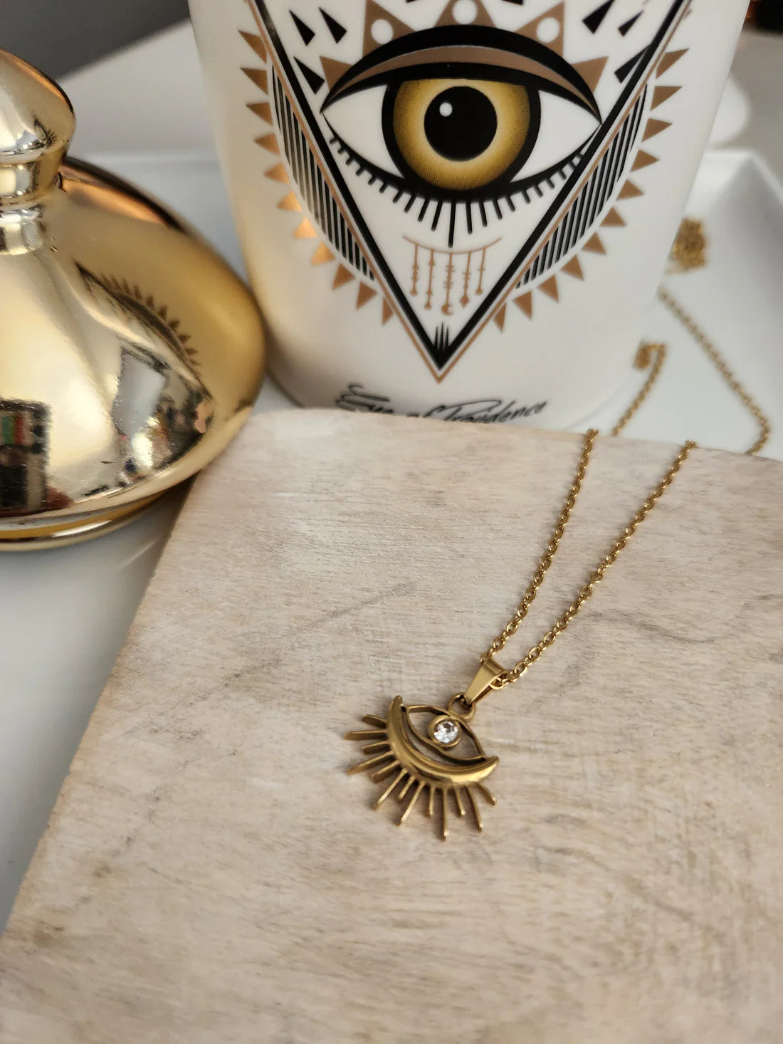 Elegant Sunburst Evil Eye Pendant Necklace, 18K gold-plated with a sparkling rhinestone, combining style and protection for everyday wear.