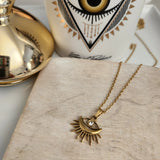 Elegant Sunburst Evil Eye Pendant Necklace, 18K gold-plated with a sparkling rhinestone, combining style and protection for everyday wear.
