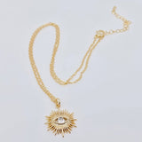 Gold-plated sunburst evil eye pendant necklace with cubic zirconia center, offering stylish protection and elegance for everyday wear.