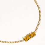Gold necklace with 'MOM' pendant on a white background