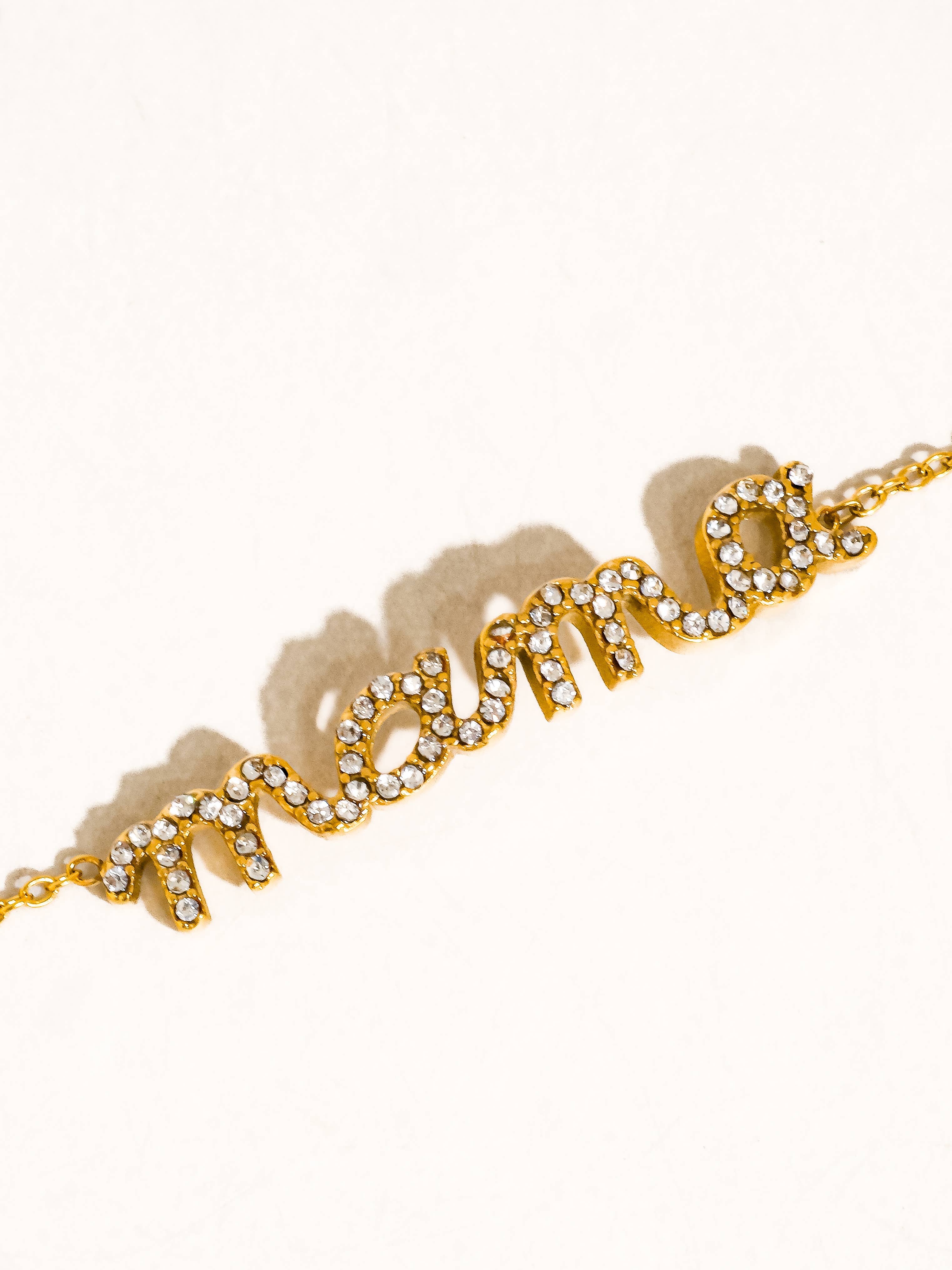Gold bracelet with 'Amour' text on a white background
