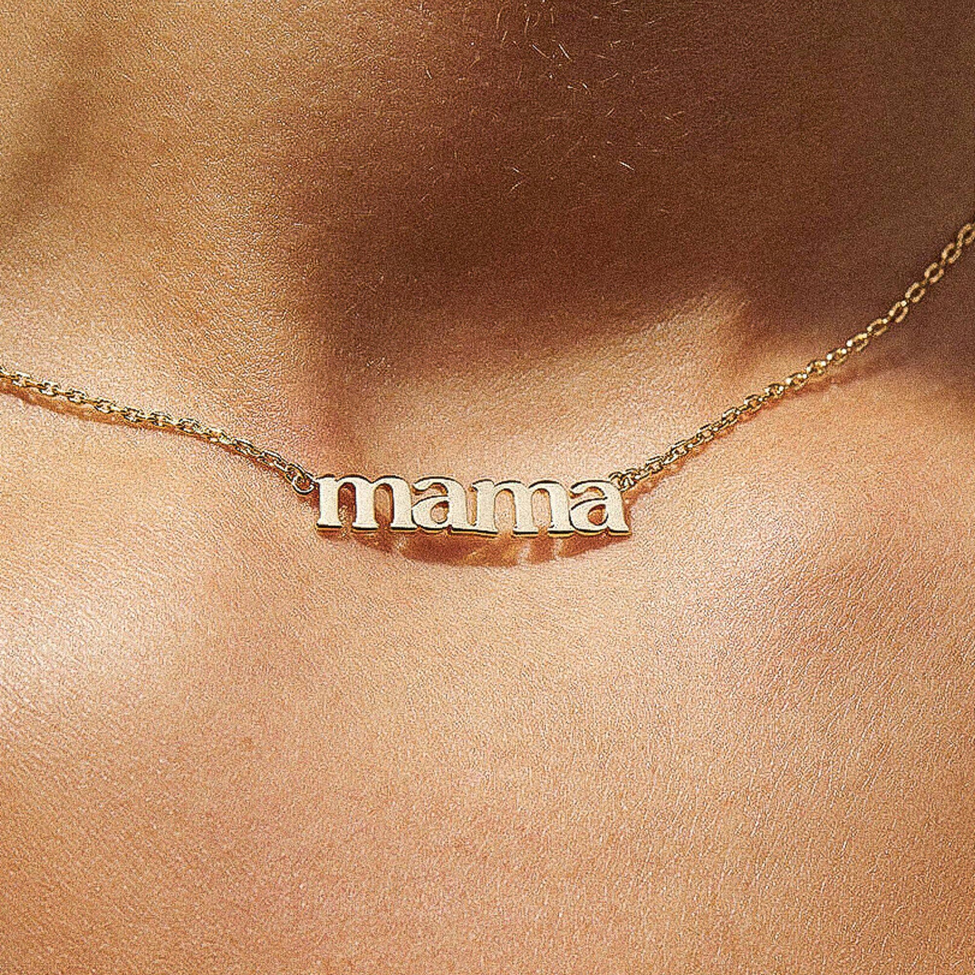 Gold 'mama' necklace on a person's neck
