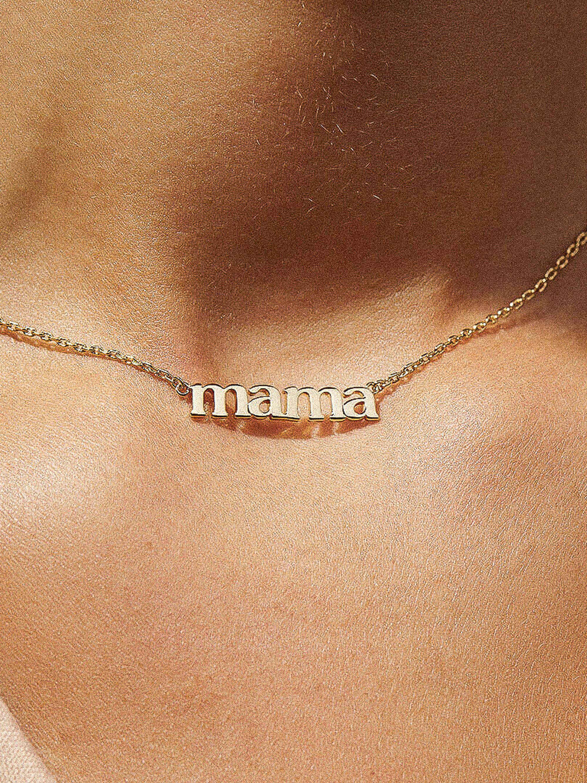 Gold 'mama' necklace on a person's neck