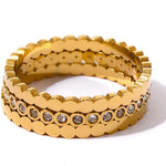 Gold ring with embedded stones on a white background