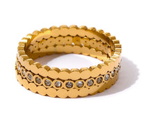 Gold ring with embedded stones on a white background