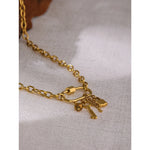 Gold necklace with key and lock charms on a light fabric background