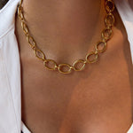 Gold chain necklace on a person wearing a white shirt
