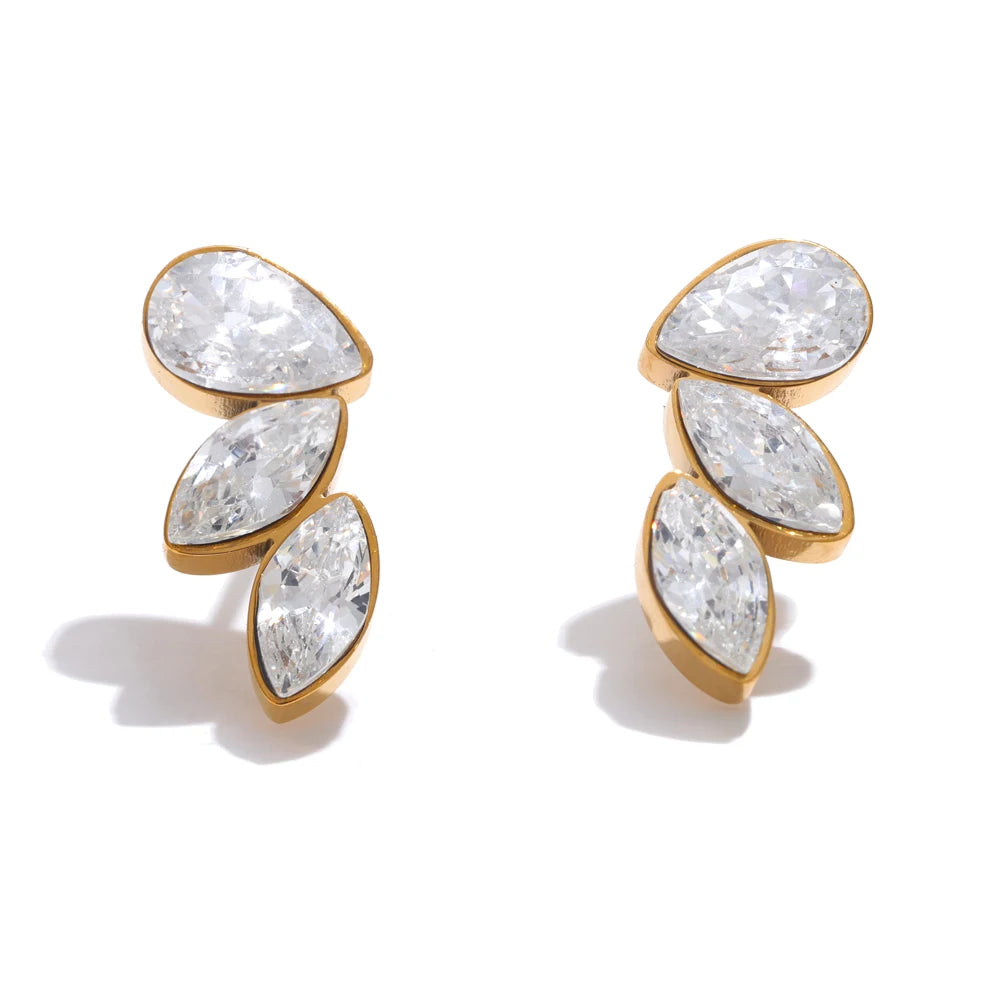 Gold earrings with clear gemstones on a white background