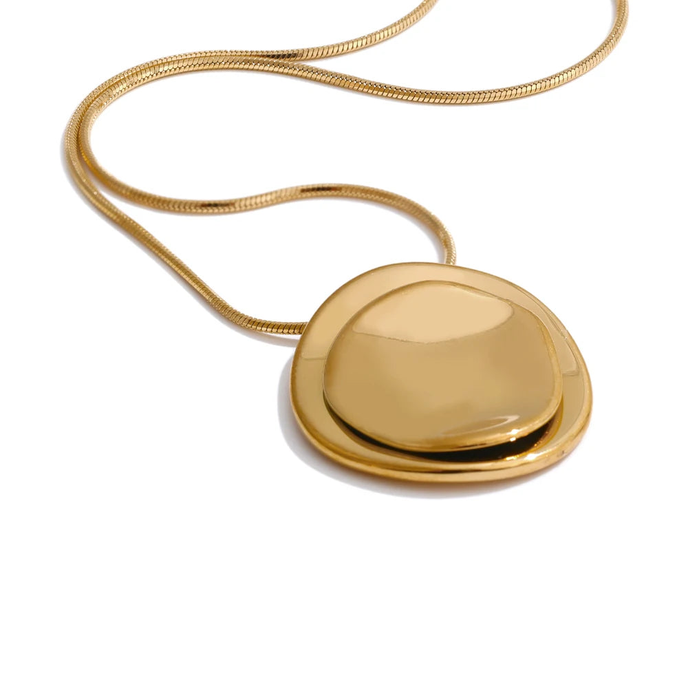 Gold necklace with a round pendant on a white background