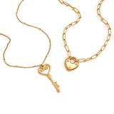 Two gold necklaces with heart-shaped key and lock pendants on a white background