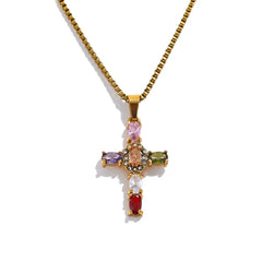 Gold cross pendant with colorful gemstones on a white background