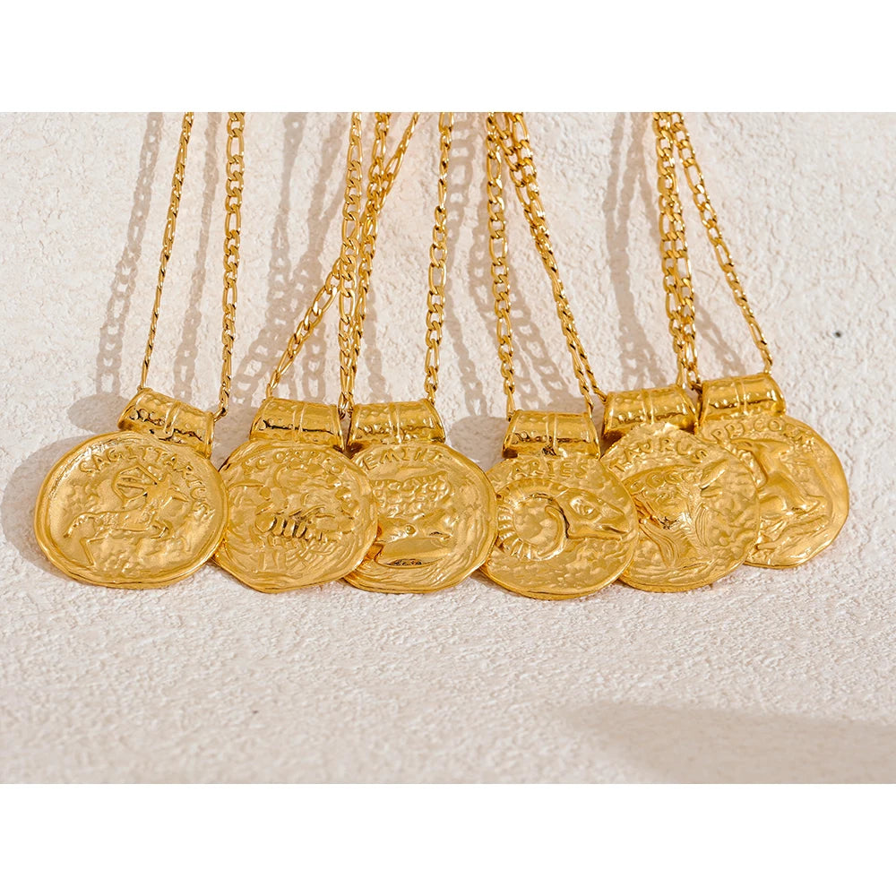Gold necklaces with coins on a textured white surface