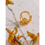 Gold ring on a textured surface with blurred autumn leaves