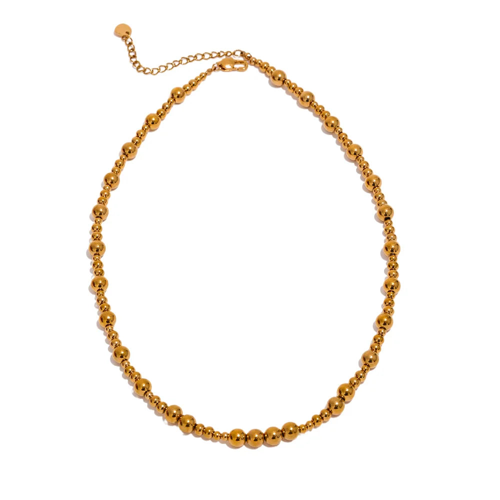 Gold beaded chain necklace on a white background