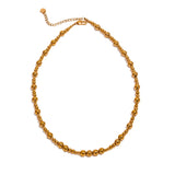 Gold beaded chain necklace on a white background