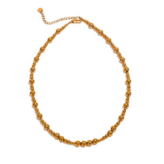 Gold beaded chain necklace on a white background