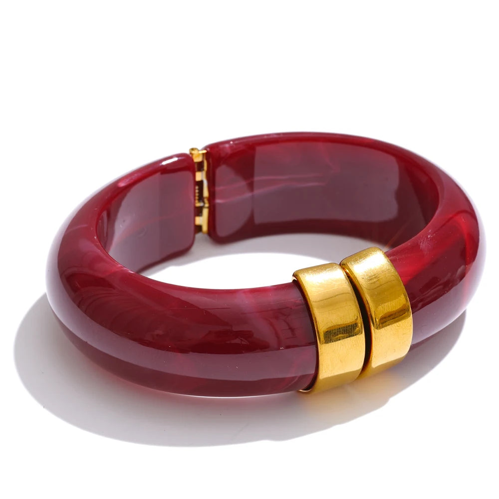 Red bracelet with gold clasp on a white background
