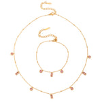 Gold necklace with pink gemstones on a white background
