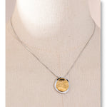 Necklace with a gold pendant on a beige background