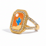Gold ring with a blue cactus design on an orange background 