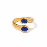 Gold ring with blue stones and measurements on a white background