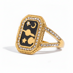 Gold ring with black gemstone and star design on a white background 