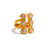 Gold ring with teardrop-shaped gemstones on a white background
