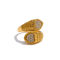 Gold ring with textured design and embedded stones on a white background