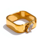 Gold ring with a clear gemstone on a white background