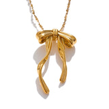 Gold bow-shaped pendant on a chain against a white background