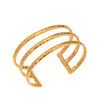 Gold bracelet with a textured design on a white background