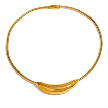 Gold necklace with a leaf-like design on a white background