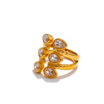 Gold ring with teardrop-shaped gemstones on a white background