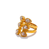 Gold ring with teardrop-shaped gemstones on a white background