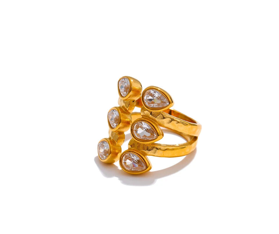 Gold ring with teardrop-shaped gemstones on a white background